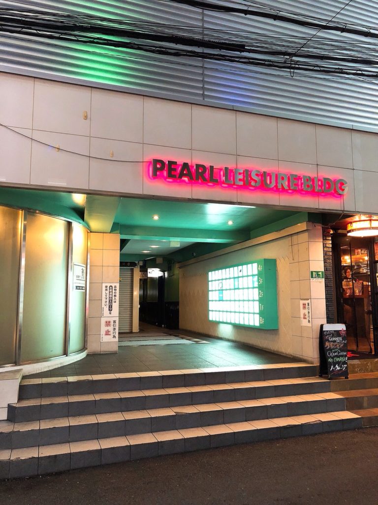 パールレジャービルの外観。ピンクのネオン看板が出ている
